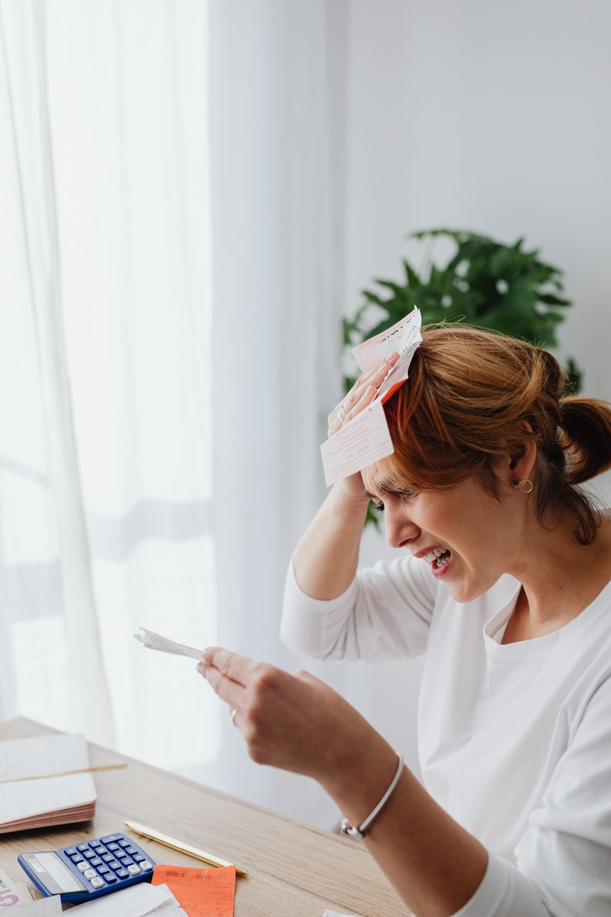 Person reviewing household bills at a desk